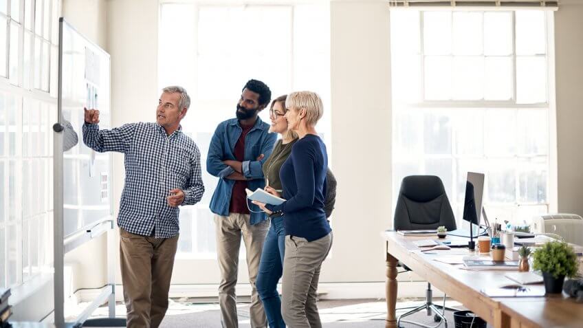 Cropped shot of a mature businessman presenting and pitching ideas to his colleagues inside an office.