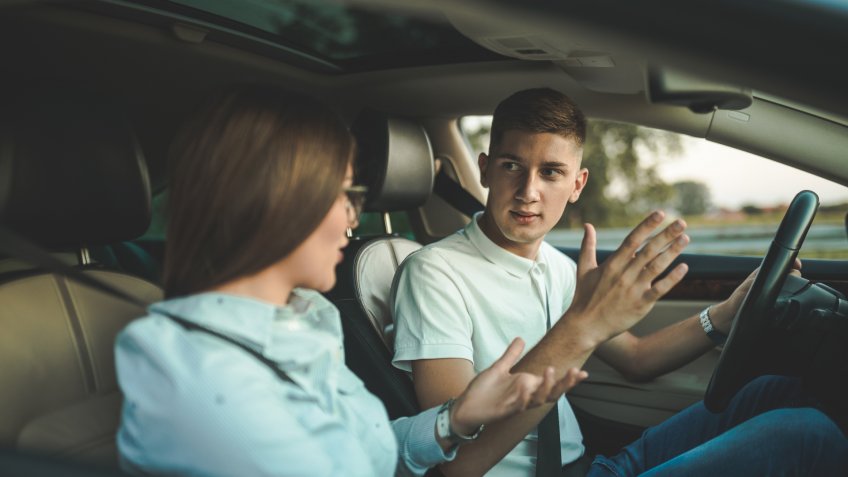 Young couple fighting in car.