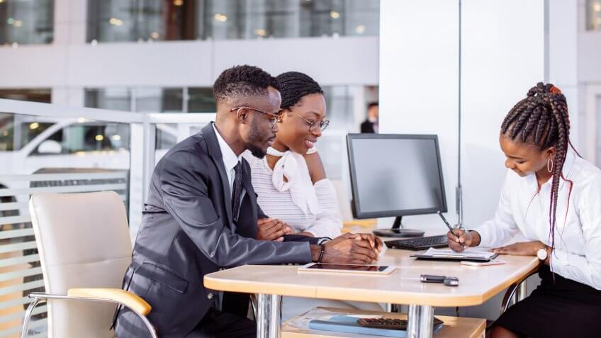 couple signing car paperwork with dealership