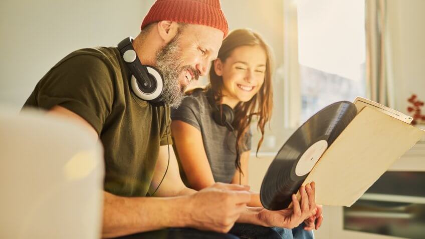 father and daughter looking at records to play on record player