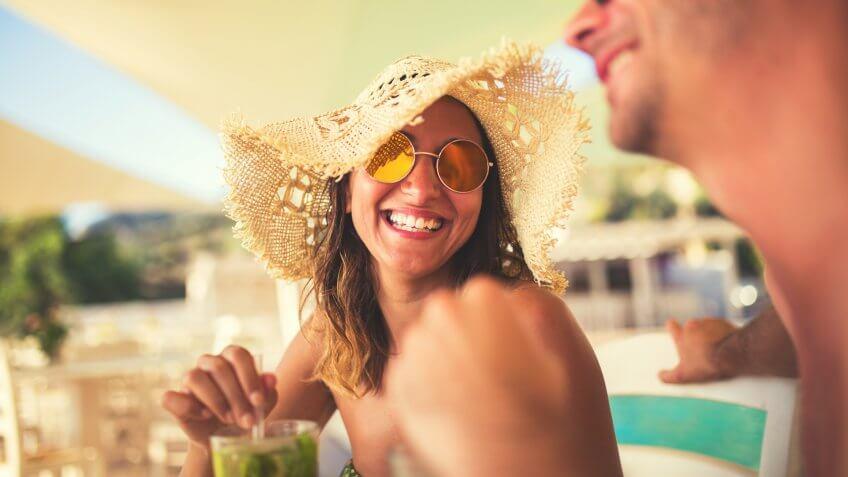 Two people enjoying vacation in Greece ,drinking coktails.