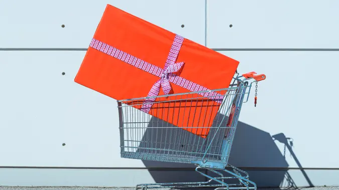 Big red gift box in shopping cart.