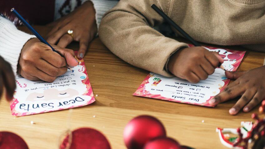 Kid writing Christmas wish list.