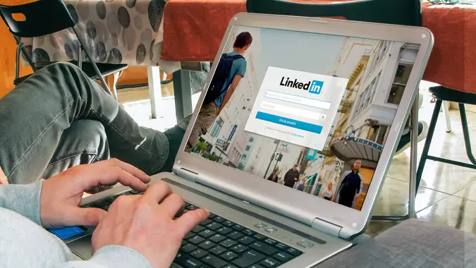 man signing into LinkedIn on laptop