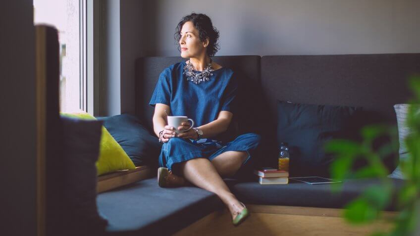 middle aged woman thinking with coffee