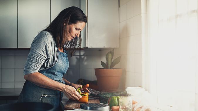 Picture of a mature woman preparing a meal in her kitchen at home.