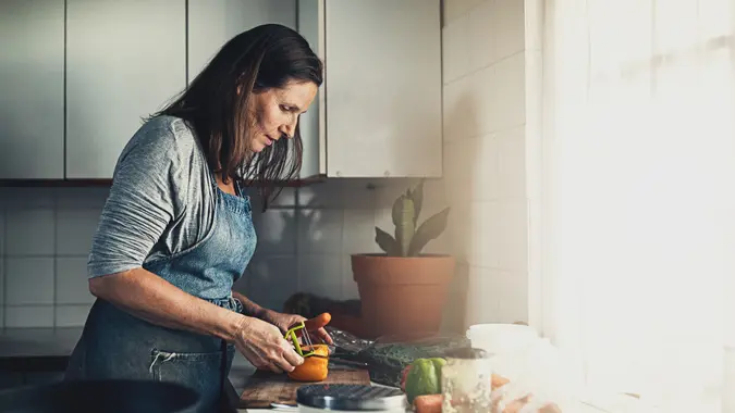 Shot of a mature woman preparing a meal in her kitchen at home.