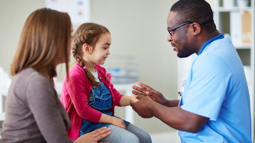 Doctor in surgery examining little girl.