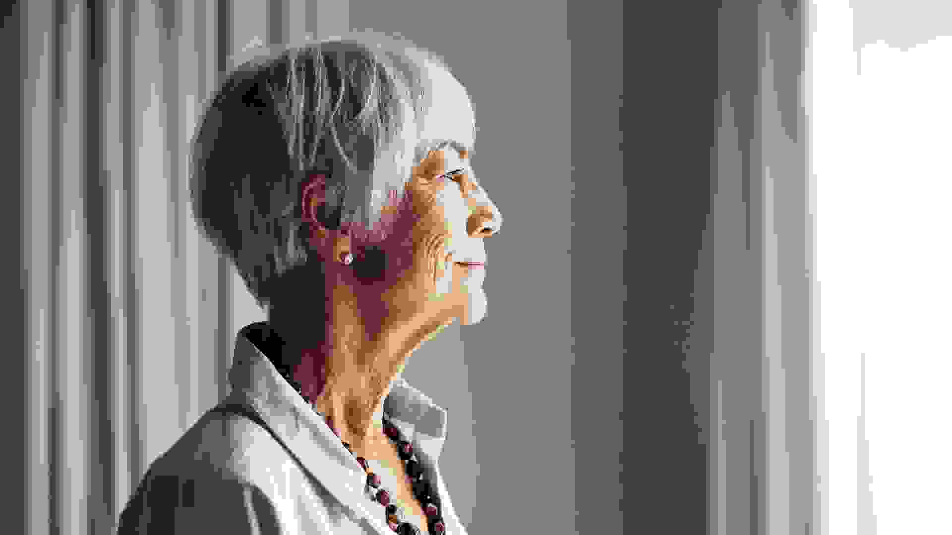 Cropped shot of a senior woman looking out the window at home.