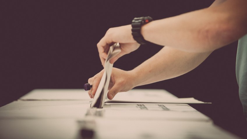 person casting ballot vote on election day