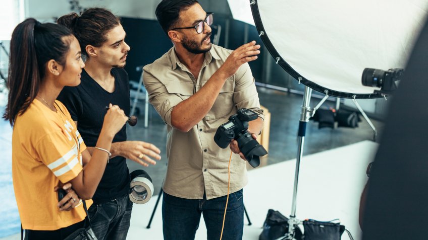 Photographer explaining about the shot to his team in the studio.
