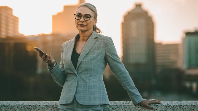senior businesswoman in suit holding smartphone for work