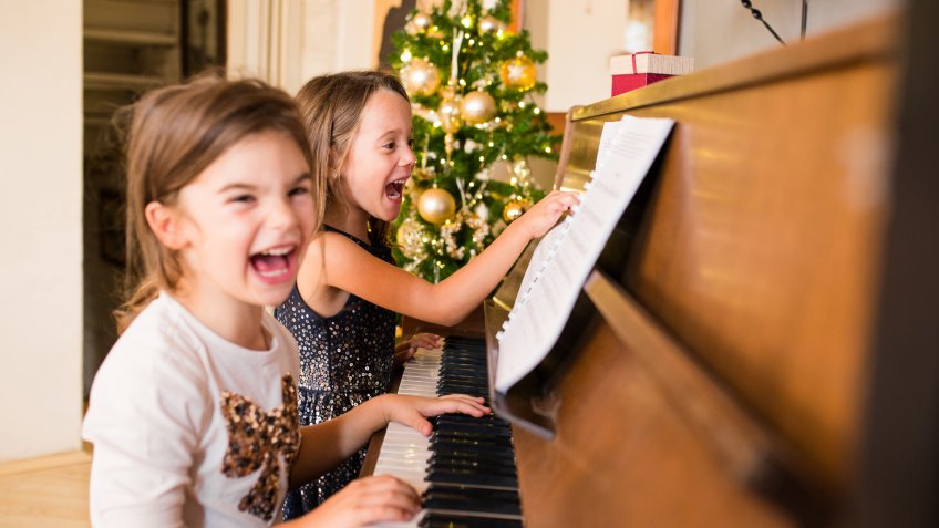 Young girls playing with piano at home.