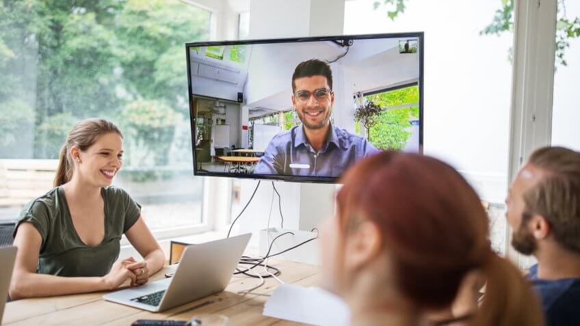 Businesswoman discussing with colleagues during video conference.