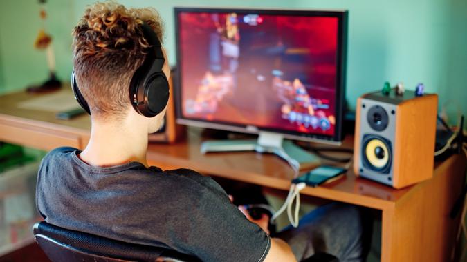Teen Boy Playing Games on Computer wearing Headphones.