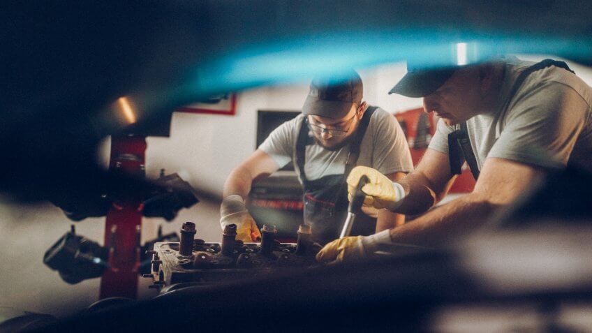 Two man working on repair of old timer.