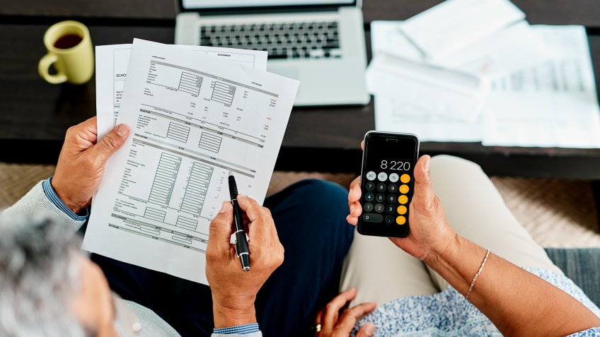 High angle shot of a couple calculating their finances together at home.