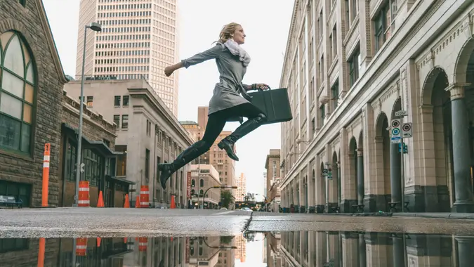 woman jumping with briefcase to work
