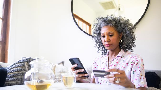 A black woman makes a purchase on her smartphone.