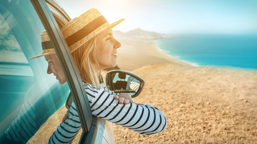 Happiness young woman sitting in her white car and look on the beautifull ocean coastline view.