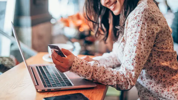 Woman is shopping online with laptop computer and credit card.