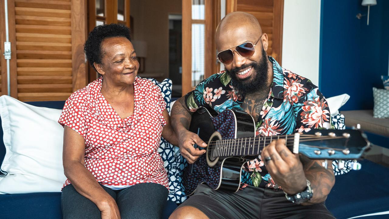Son playing guitar to his mother.