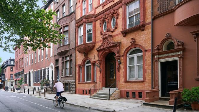 urban street with elegant old brownstone style townhouses or apartment buildings.