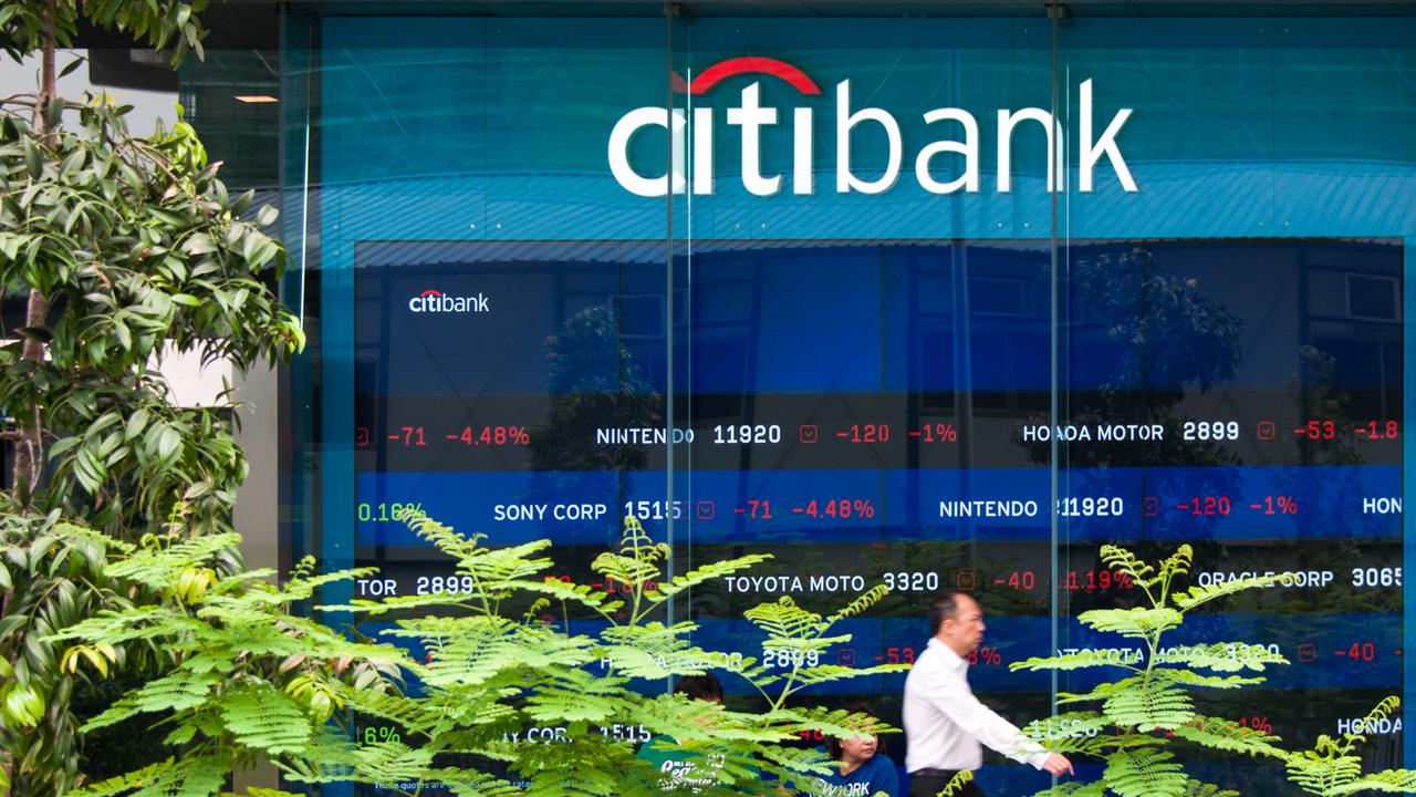 "Singapore - April 11, 2012: Citibank offices in Singapore with people sitting in front and one business man passing by.