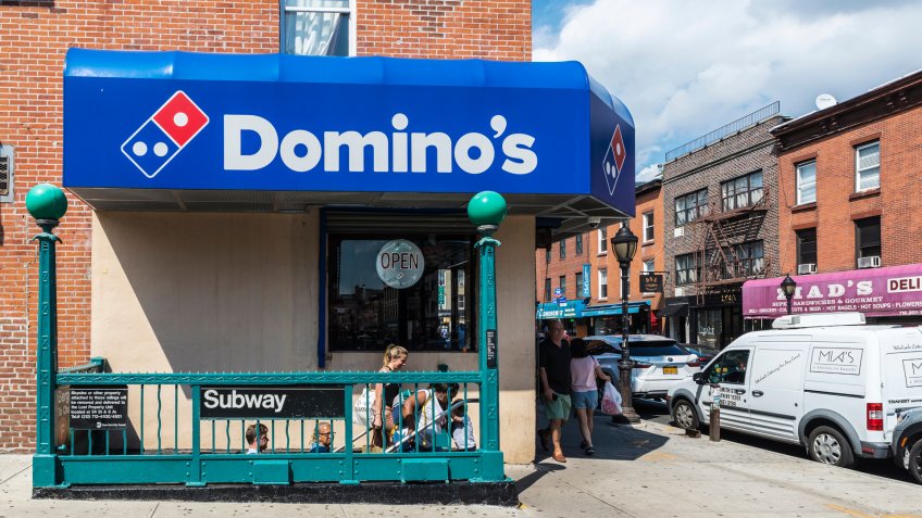 New York City, USA - July 26, 2018: Domino´s Pizza next to a subway station with people around in Brooklyn, Manhattan, New York City, USA.