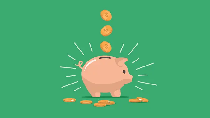 Pink piggy bank with falling coins.