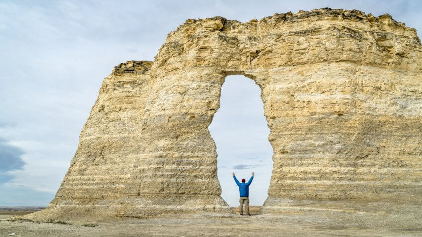 arch in Monument Rocks (Chalk Pyramids) in western Kansas with a human figure added for a scale.
