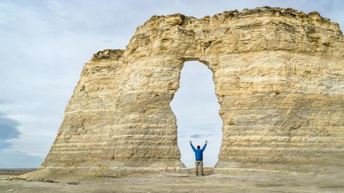 arch in Monument Rocks (Chalk Pyramids) in western Kansas with a human figure added for a scale.
