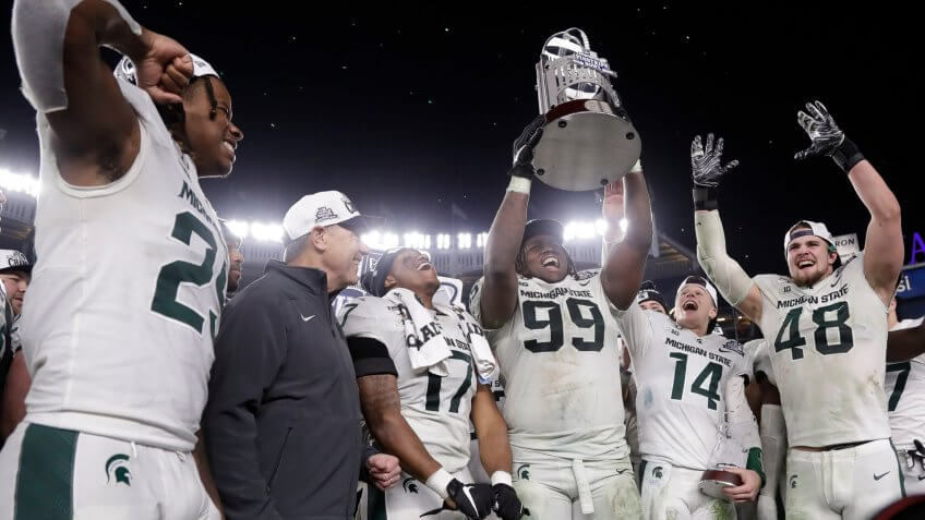 Mandatory Credit: Photo by Frank Franklin II/AP/Shutterstock (10513763q)Michigan State's Raequan Williams (99) holds up the trophy after the team's Pinstripe Bowl NCAA football game against Wake Forest, in New York.