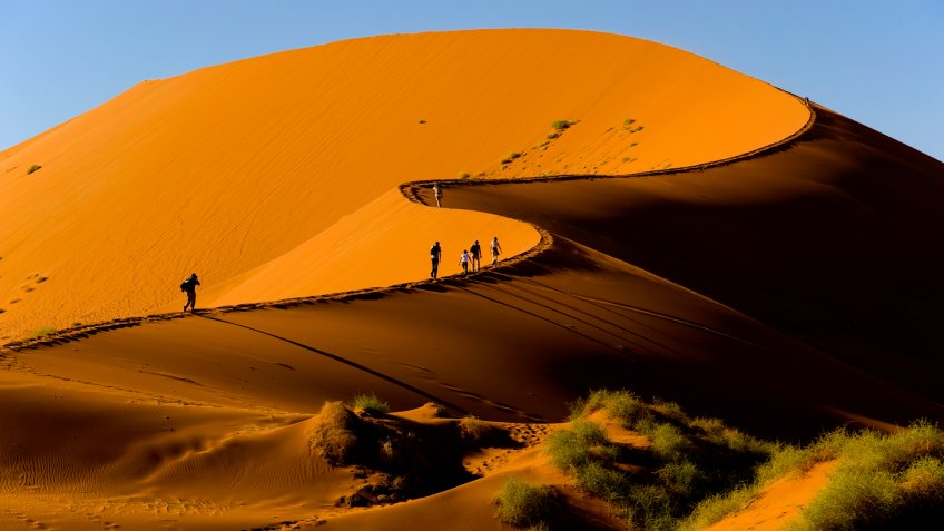 Tourists climbing Sossusvlei dune, Naukluft National Park, Namibia.