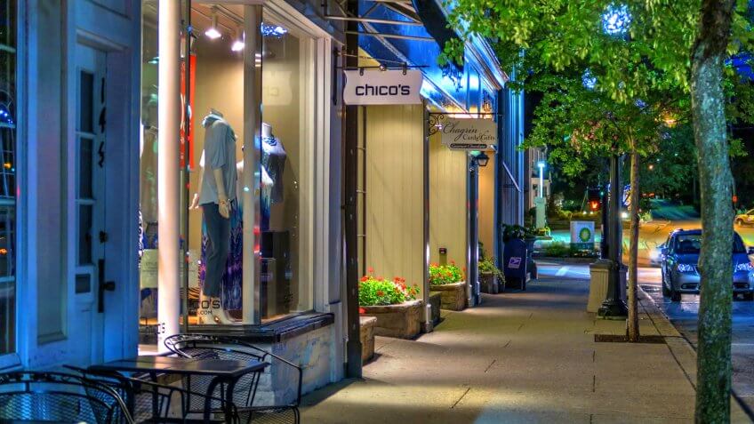 Chagrin Falls, Ohio / USA - July 17, 2015: Summer Urban Night Scene of Shops, Trees, Sidewalk and Chico's Store on Main Street in the Business District of Historical Downtown Chagrin Falls, Ohio.