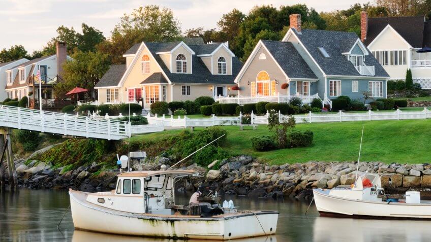 "Fishing boats with houses in background at sunrise, blurred water by long exposure, square picture (Perkins Cove, Ogunquit, Maine USA).