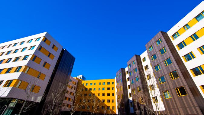 Modern and stylish multistory buildings white yellow and brown colors strict urban design with rectangles of windows, built in orderly rows of synchronous.