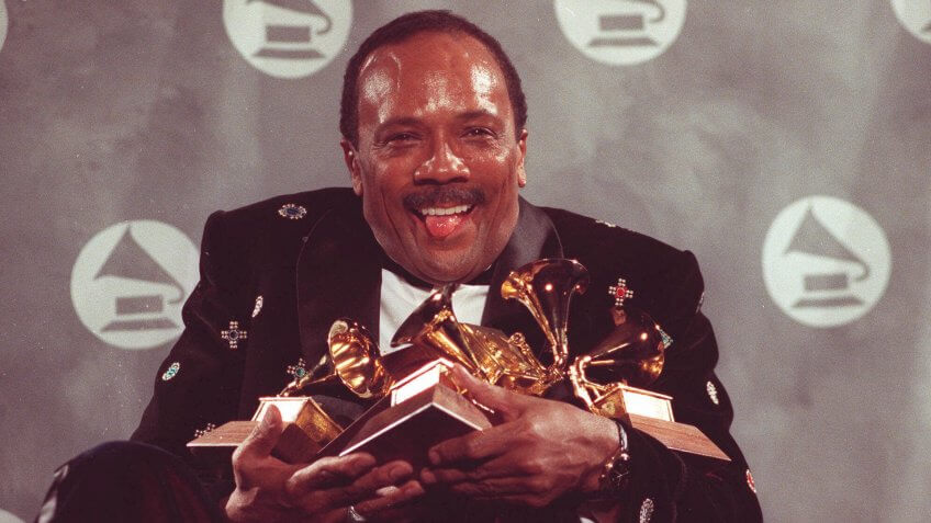 Quincy Jones cradles his Grammy awards,including the album of the year award, for his eclectic album "Back on the Block" during the 33rd annual Grammy Awards ;at New York's Radio City Music Hall night of Feb.