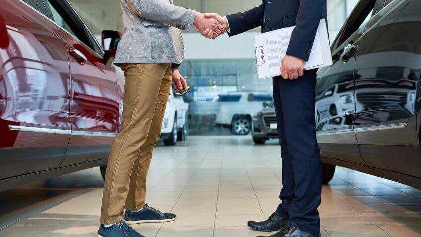 car dealer shaking hands with customer
