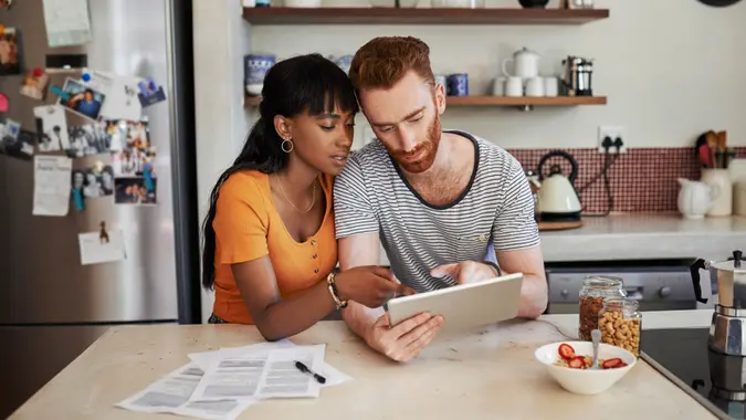 Shot of a young couple using a digital tablet at home.