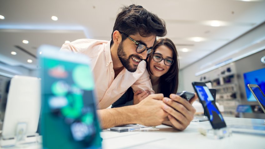 couple searching for smartphones in tech store