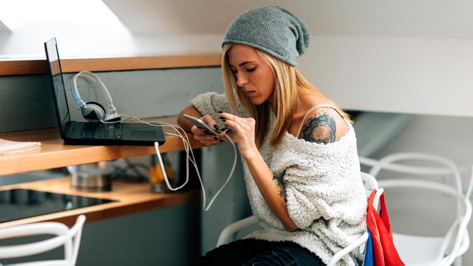 Young tattooed female developer working in her start-up office.