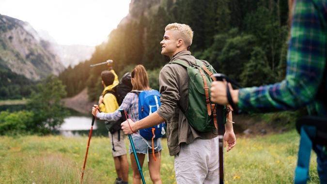 Group of hikers and friends walking on a mountain at sunset.