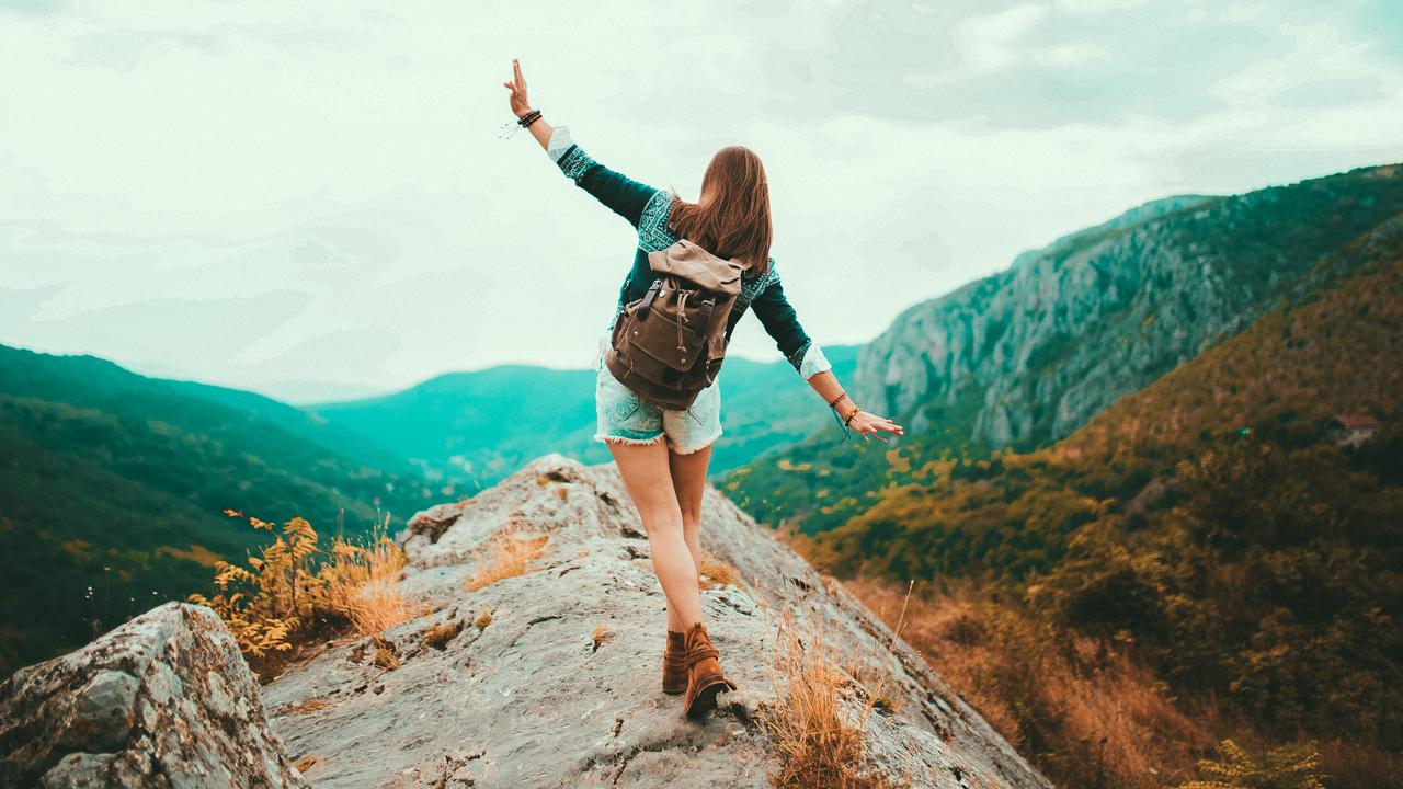 Young Hippie girl taking a walk on top of a mountain and enjoying the day.