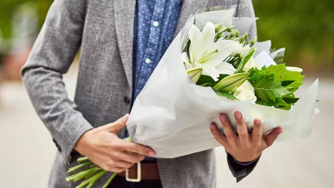 Cropped shot of a man holding a bouquet of flowers.