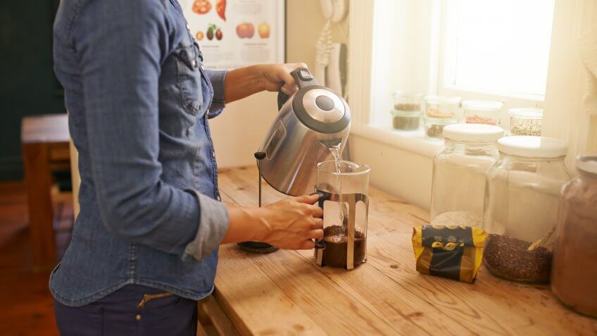 Cropped shot of an unrecognizable woman making filter coffee at home.