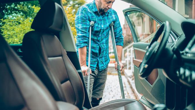 man using crutches is about to take the car.