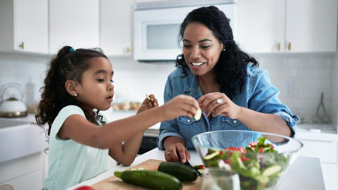 Mother and daughter preparing meal at home.