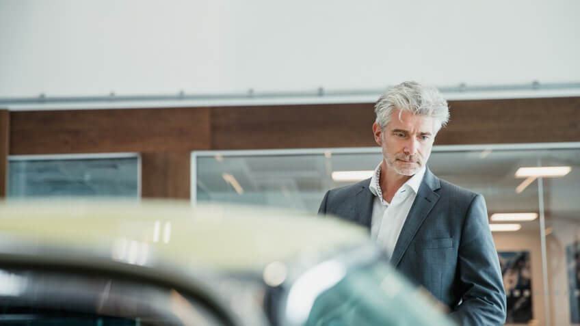 Customer looking in through the window of a classic car.