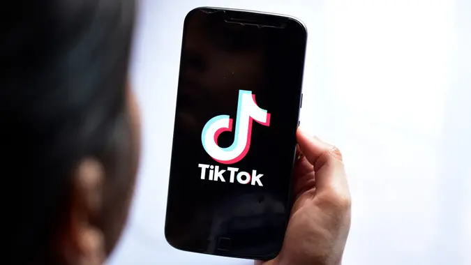 New Delhi, Inde - 23 avril 2019 : femme tenant un téléphone motorola avec interdiction de diffusion multimédia et application TikTok vidéo à l'écran.